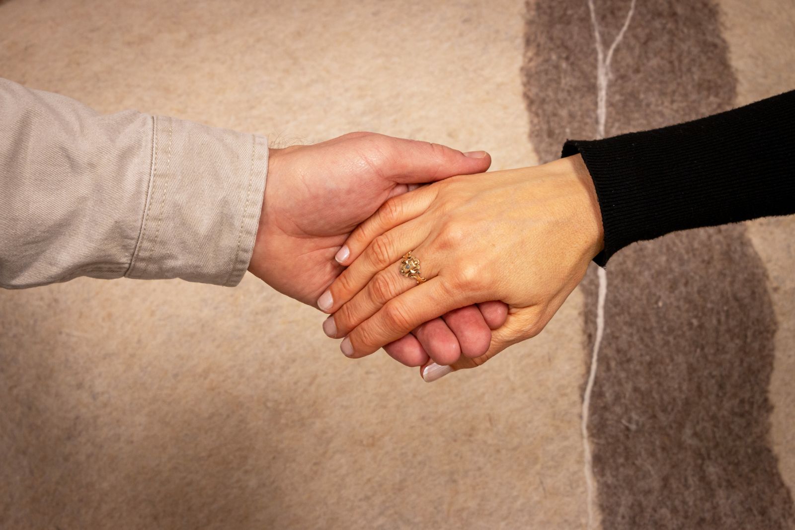 Zwei Hände, die sich vorsichtig berühren – Bindungsstile prägen, wie Nähe in einer Partnerschaft entsteht